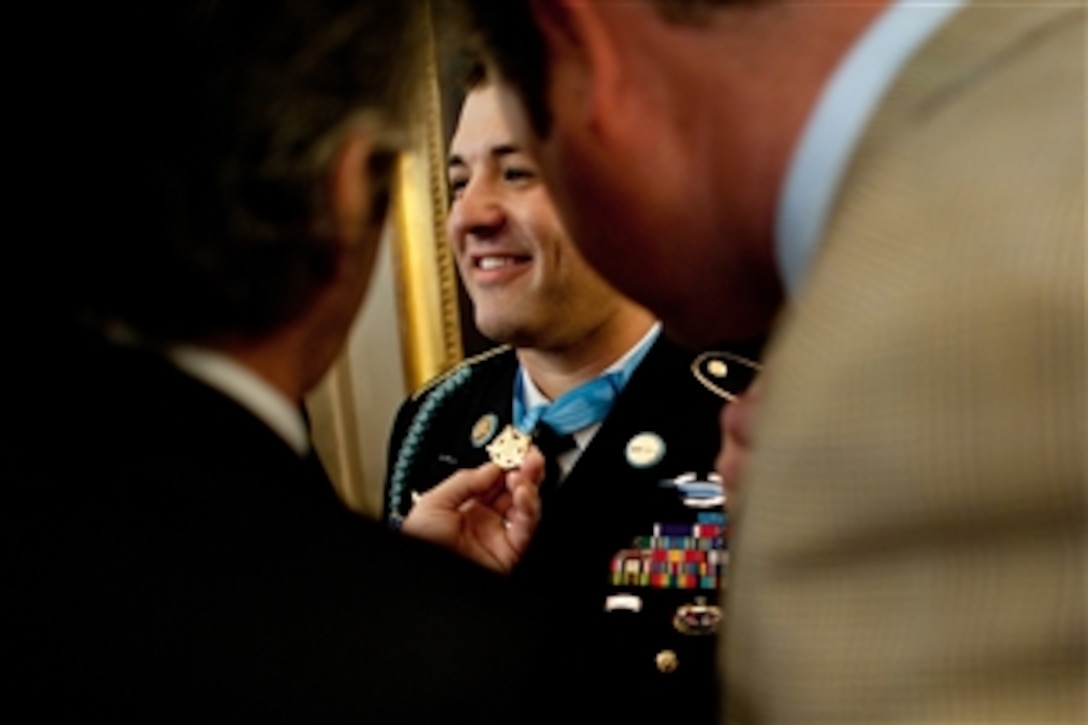 Friends of Army Sgt. 1st Class Leroy Arthur Petry inspect the Medal of Honor he received at the White House in Washington, D.C., on July 12, 2011.   