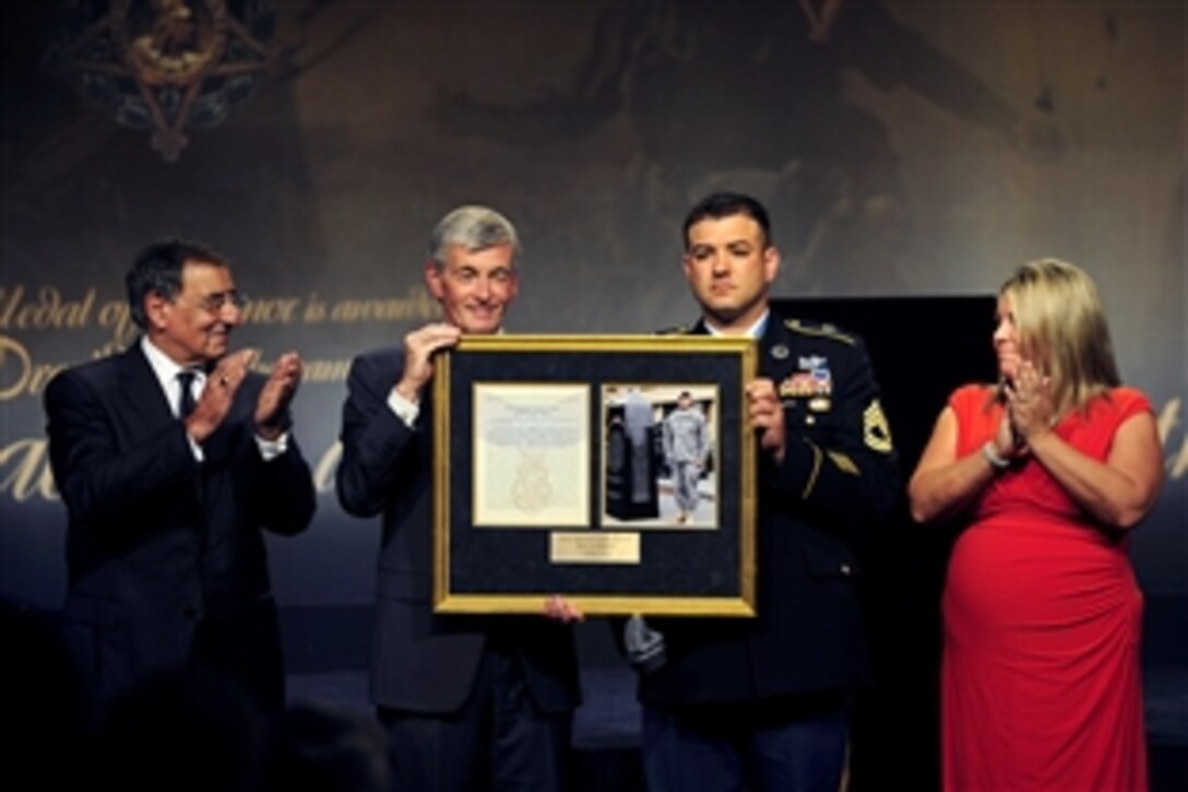 Medal of Honor recipient Army Sgt. 1st Class Leroy A. Petry receives a photo and citation during a ceremony to induct him into the Hall of Heroes from Army Secretary John McHugh as Defense Secretary Leon E. Panetta and Petry's wife, Ashley, applaud during a ceremony at the Pentagon, July 13, 2011.