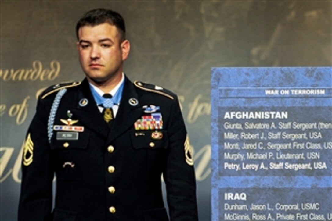 Medal of Honor recipient Army Sgt. 1st Class Leroy A. Petry stands next to the Hall of Heroes plaque now bearing his name after it is unveiled during a ceremony at the Pentagon, July 13, 2011.