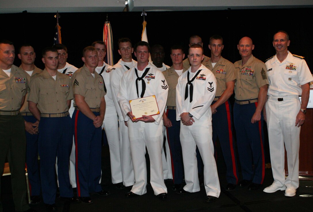 Petty Officer 2nd Class Jacob Emmott, a corpsman with 1st Battalion, 2nd Marine Regiment, 2nd Marine Division, stands with his Silver Star citation with, from right to left, Adm. Jonathan W. Greenert, the Vice Chief of Naval Operations, Sgt. Maj. Michael P. Barrett, the sergeant major of the Marine Corps, and fellow Marines and sailors from 1/2 at the Third Annual Naval Safe Harbor Award Ceremony in Washington D.C., July 14, 2011. Emmott was awarded the Silver Star, the third highest award for valor in the United States armed forces, for his actions in Helmand Province, Afghanistan, 2010.