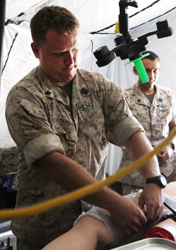 Petty Officer 2nd Class Kirk R. Atkinson, instructor, Advanced Training Group, 1st Medical Battalion, Combat Logistics Regiment 15, 1st Marine Logistics Group, provides medical care to a simulated casualty at Camp Pendleton, Calif., July 14. As a member of the ATG, he helps mentor members of Shock Trauma Platoons, which are like mobile operating rooms, as they prepare to deploy to Afghanistan in support of coalition forces.::r::::n::