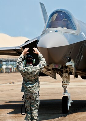 F-35 Lightning II joint strike fighter crew chief, Tech. Sgt. Brian West, marshals his aircraft to a stop for the first time at Eglin Air Force Base, Fla., July 14.  Aircraft 0747 is DoD’s newest aircraft.  (U.S. Air Force photo/Samuel King Jr.)
