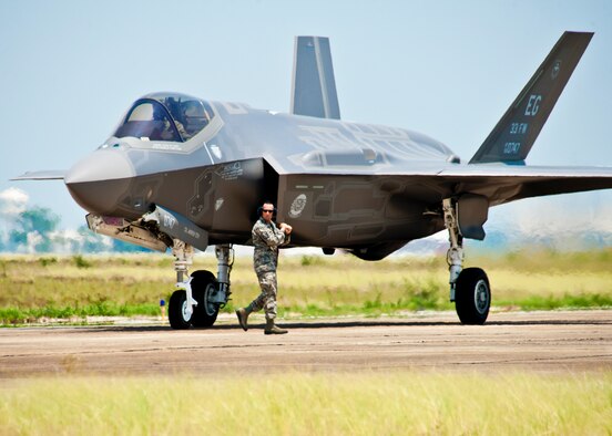 A 33rd Fighter Wing maintainer moves by DoD's newest aircraft, the F-35 Lightning II joint strike fighter, before giving the order to taxi at Eglin Air Force Base, Fla., July 14.   This marks the first JSF aircraft to arrive to its new home, the 33rd FW.  (U.S. Air Force photo/Samuel King Jr.)