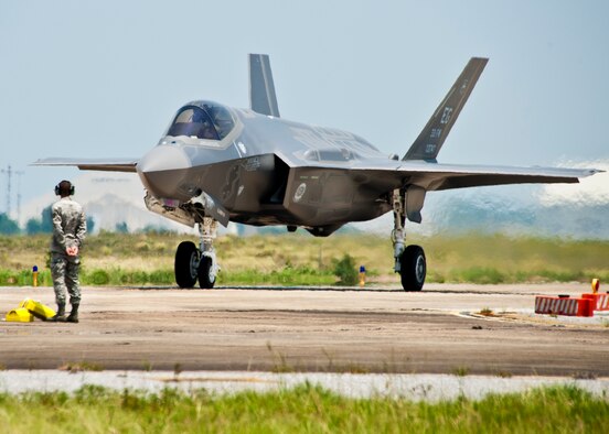 A 33rd Fighter Wing maintainer watches as the first F-35 Lightning II joint strike fighter taxis in to its new home at Eglin Air Force Base, Fla., July 14.  (U.S. Air Force photo/Samuel King Jr.)