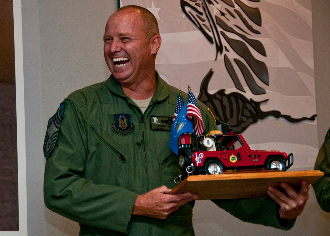 Chief Master Sgt. Thomas Mason, of the 711th Special Operations Squadron, guards his newly acquired prop as the 919th Special Operations Wing's newest "Jeep Chief" during his chief induction ceremony at Duke Field July 9.  Following Air Force tradition, Mason must keep the Jeep model with him at all times until the next new chief is similarly promoted. (U.S. Air Force photo/Tech. Sgt. Samuel King Jr.)