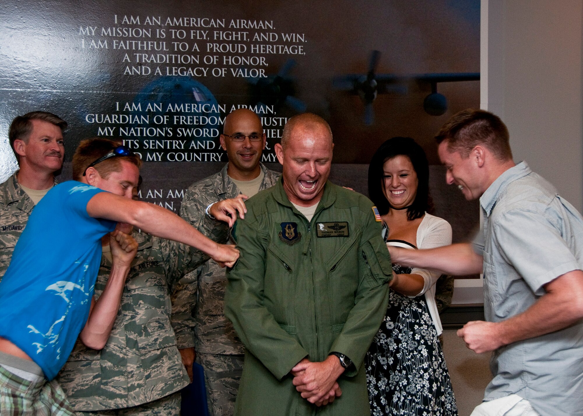 Chief Master Sgt. Thomas Mason, of the 711th Special Operations Squadron, has his new chief stripes tacked on by his two sons at a ceremony at Duke Field July 9.  (U.S. Air Force photo/Tech. Sgt. Samuel King Jr.)
