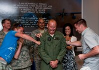 Chief Master Sgt. Thomas Mason, of the 711th Special Operations Squadron, has his new chief stripes tacked on by his two sons at a ceremony at Duke Field July 9.  (U.S. Air Force photo/Tech. Sgt. Samuel King Jr.)
