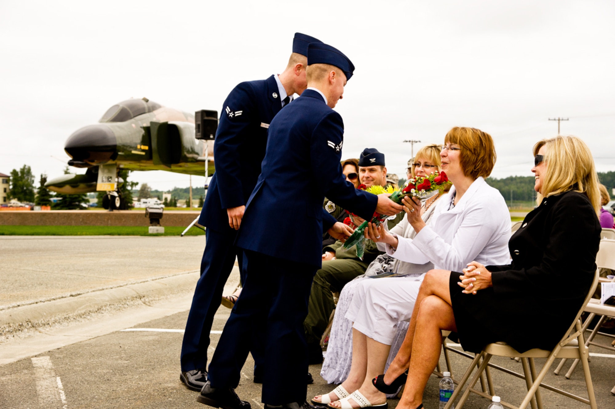 JOINT BASE ELMENDORF-RICHARDSON, Alaska -- Airman 1st Class Aaron Miller of the 703rd Aircraft Maintenance Squadron (foreground) and Airman1st Class Joseph Celona of the 3rd Aircraft Maintenance Squadron, present flowers to Anne Johnson and Christine Stimac, 
respectively. (U.S. Air Force photo/Johnathon Green)