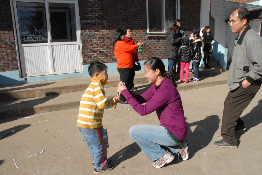 KUNSAN AIR BASE, Republic of Korea -- 1st Lt. Eleanor Dormire, 8th Operations Group intelligence training and readiness deputy chief, shares candy with a child at the Il Mag Won Orphanage near here Dec. 11, 2010. Dormire was one of more than 100 volunteers who helped host a party for the orphanage during the holiday season. (U.S. Air Force photo/Capt. Sheryll Klinkel)