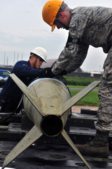 KUNSAN AIR BASE, Republic of Korea -- Airman Aaron Fierros and Airman 1st Class Stephen Whitemore, 8th Maintenance Squadron conventional maintenance crew members, cross load inert munitions from trailer to trailer to prepare frags for Kunsan and theater support package aircraft here July 13 for the upcoming Operational Readiness Exercise. The exercise is conducted to ensure members of the Wolf Pack remain ready to execute its mission of ?Defend the Base, Accept Follow on Forces and Take the Fight North.? (U.S. Air Force photo/Senior Airman Brittany Y. Bateman)