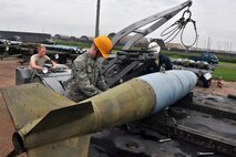 KUNSAN AIR BASE, Republic of Korea -- Airman Aaron Fierros and Airman 1st Class Stephen Whitemore, 8th Maintenance Squadron conventional maintenance crew members, cross load inert munitions from trailer to trailer to prepare frags for Kunsan and theater support package aircraft here July 13 for the upcoming Operational Readiness Exercise. The exercise is conducted to ensure members of the Wolf Pack remain ready to execute its mission of ?Defend the Base, Accept Follow on Forces and Take the Fight North.? (U.S. Air Force photo/Senior Airman Brittany Y. Bateman)