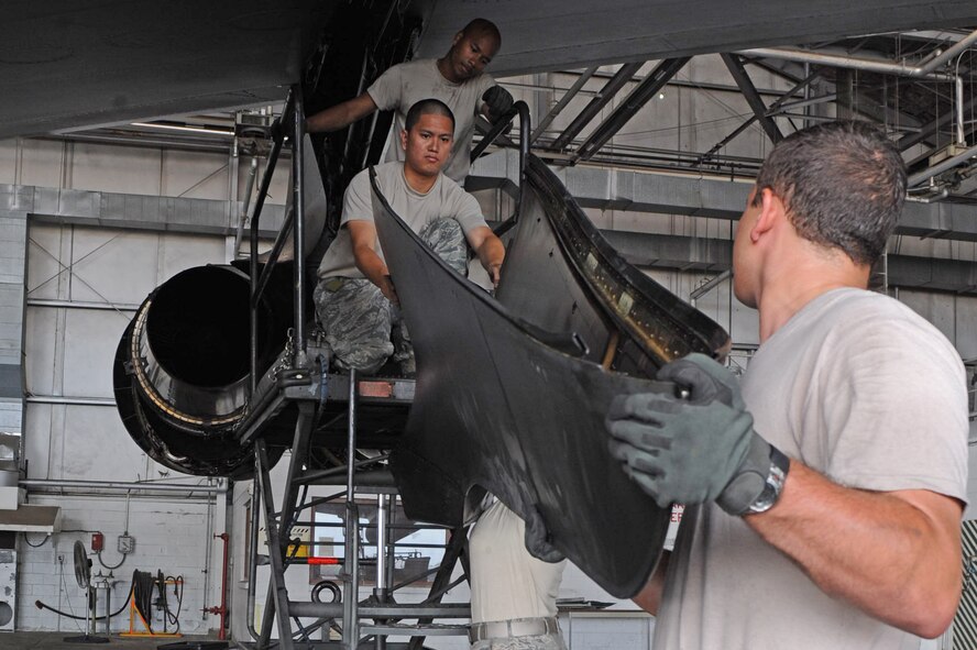 Airman 1st Class Brandon Vorndran and Airman 1st Class ReAnna Pierce, both from 2nd Maintenance Squadron, lift a trailing edge power pod fairing to Airman 1st Class Justen Laganse and Airman 1st Class Deven Sherk, 2 MXS, in a hangar on Barksdale Air Force Base, La., July 14. The fairing protects the engine-strut and fuel lines while improving the aerodynamics of the B-52H Stratofortress. (U.S. Air Force photo/Airman 1st Class Micaiah Anthony)(RELEASED) 