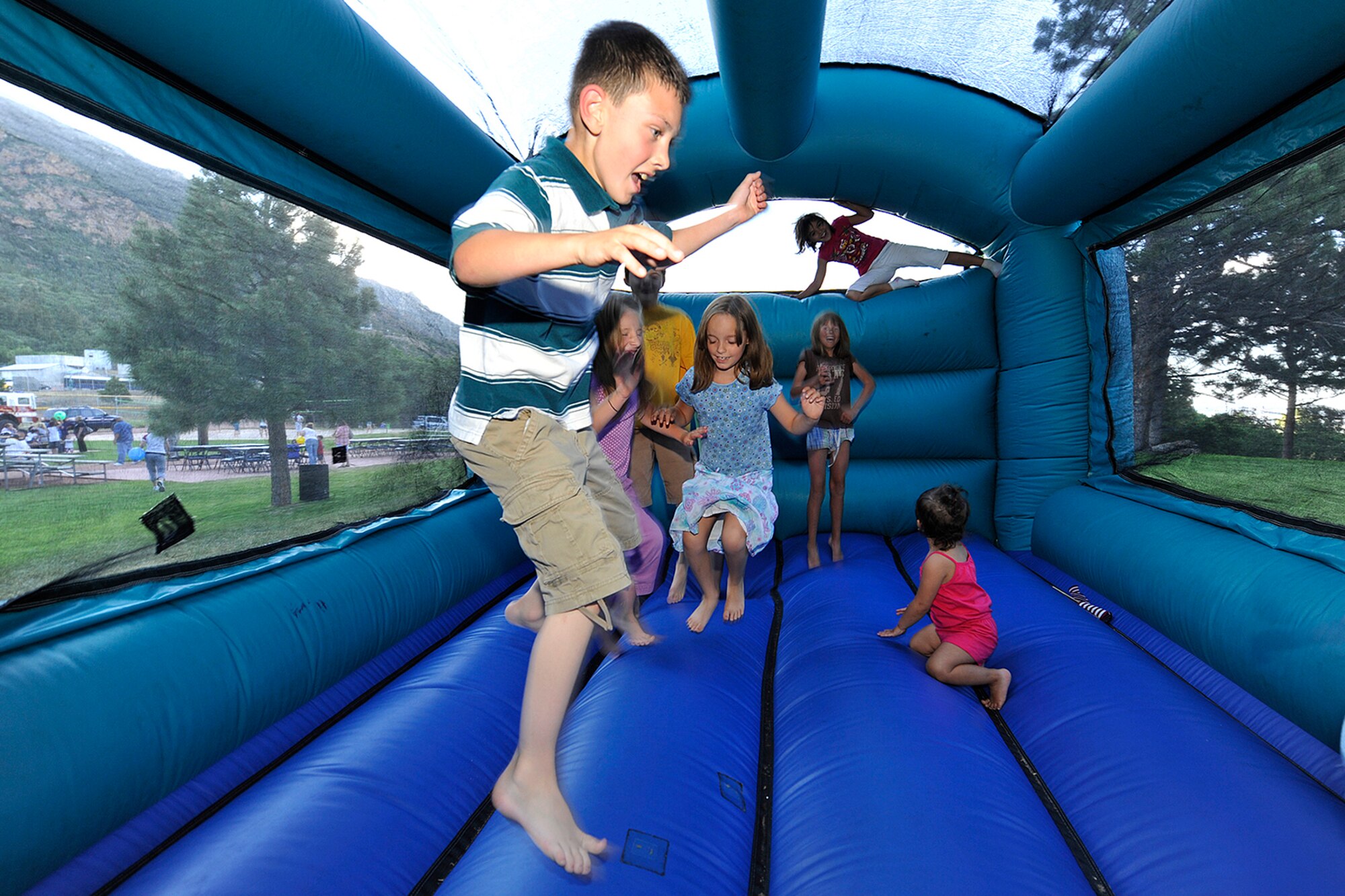 CHEYENNE MOUNTAIN AIR FORCE STATION, Colo. – Children of deployed Airmen play in the bouncy castle during the Deployed Family Dinner at Cheyenne Mountain Air Force Station Mountain Man Park on June 30, 2011. The free dinner is held every month to support families of deployed men and women stationed at Peterson AFB and Cheyenne Mountain AFS. (U.S. Air Force photo/Rob Bussard)