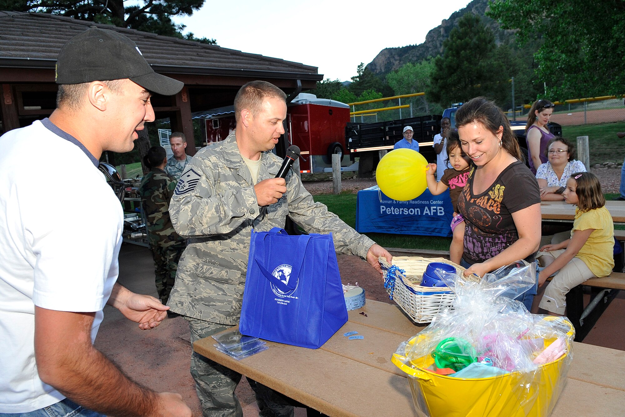 CHEYENNE MOUNTAIN AIR FORCE STATION, Colo. – Andrea Rodriguez, wife of Master Sgt. Christobal Rodriguez, collects the first door prize given away during the Deployed Family Dinner at Cheyenne Mountain Air Force Station Mountain Man Park on June 30, 2011. The free dinner is held every month to support families of deployed men and women stationed at Peterson AFB and Cheyenne Mountain AFS. (U.S. Air Force photo/Rob Bussard)