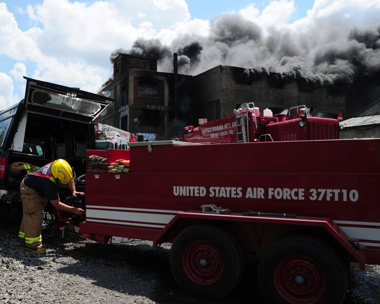 Niagara Falls Air Reserve Station Firefighters respond to a call for mutual aid support. The three-alarm fire at a warehouse in Buffalo started at approximately 5 a.m. on July 13, 2011. Lt. Kevin Mitchell (shown) and Capt. Steve Check were there to support the Buffalo Fire Department with back up foam to be used on a huge fire at a warehouse that stored oil, grease, and propane. (U.S. Air Force Reserve photo by Peter Borys) 

