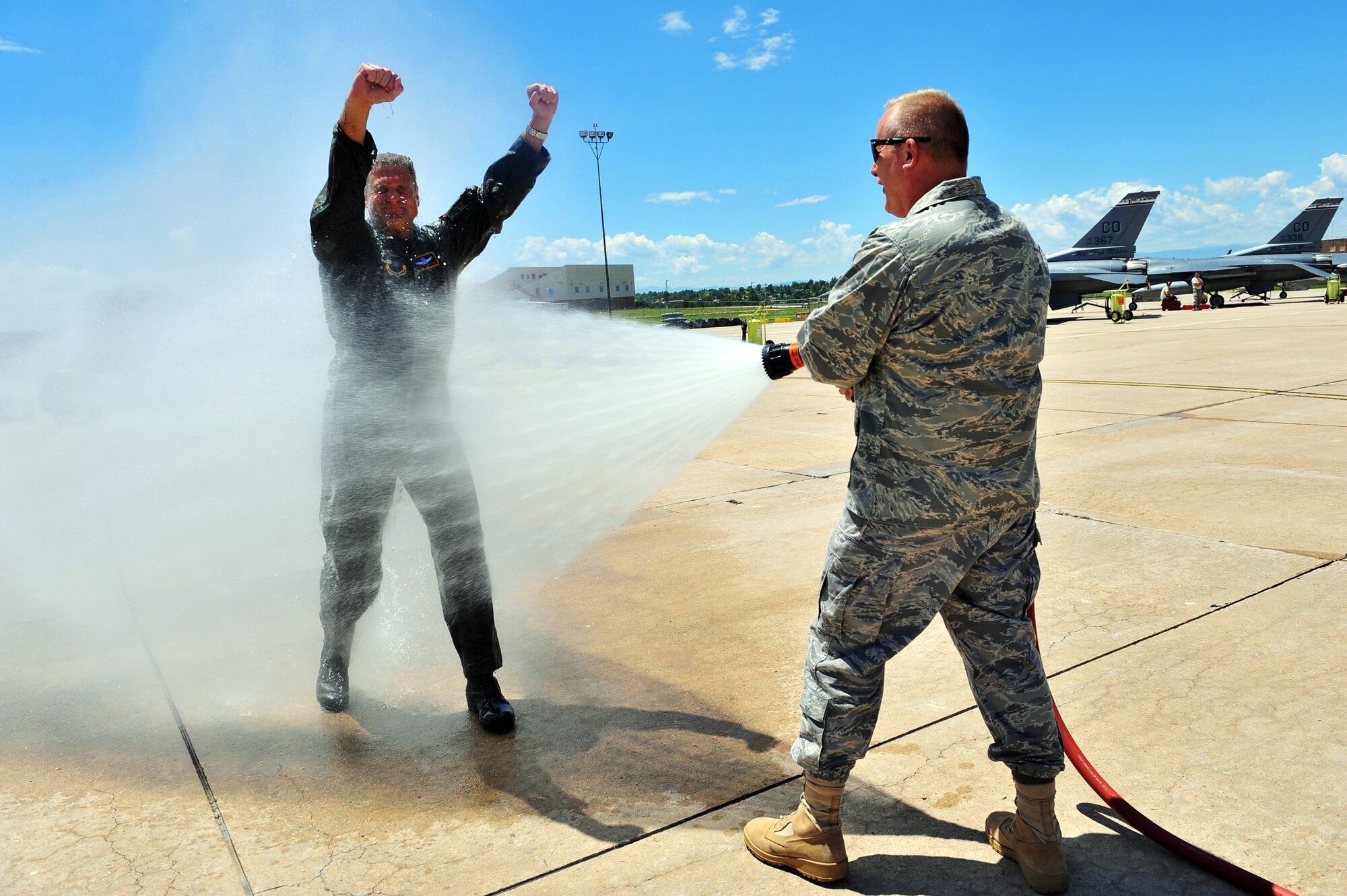 BUCKLEY AIR FORCE BASE, Colo. -- Colonel Trent Pickering, 460th Space Wing vice commander gets sprayed down by Col. Daniel Dant, 460th SW commander, after his incentive flight here July 13. 