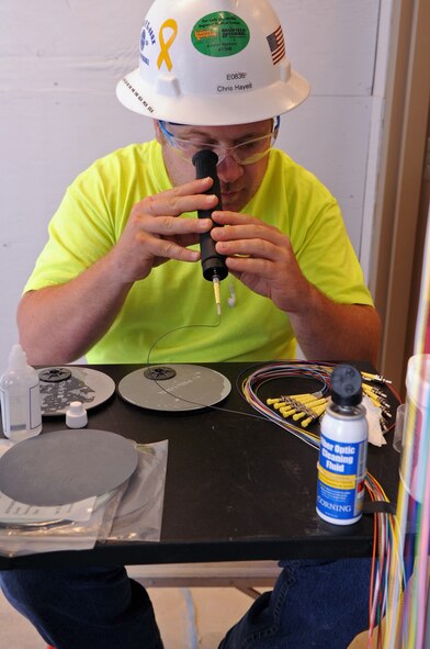 Chris Hayes, a contracted communication technician, looks through an optical scope in a newly renovated building on Barksdale Air force Base, La., July 13. The optical scope is used to magnify the end of fiber-optic cable to ensure that it is in good condition. (U.S. Air Force photo/Senior Airman La'Shanette V. Garrett)(RELEASED)