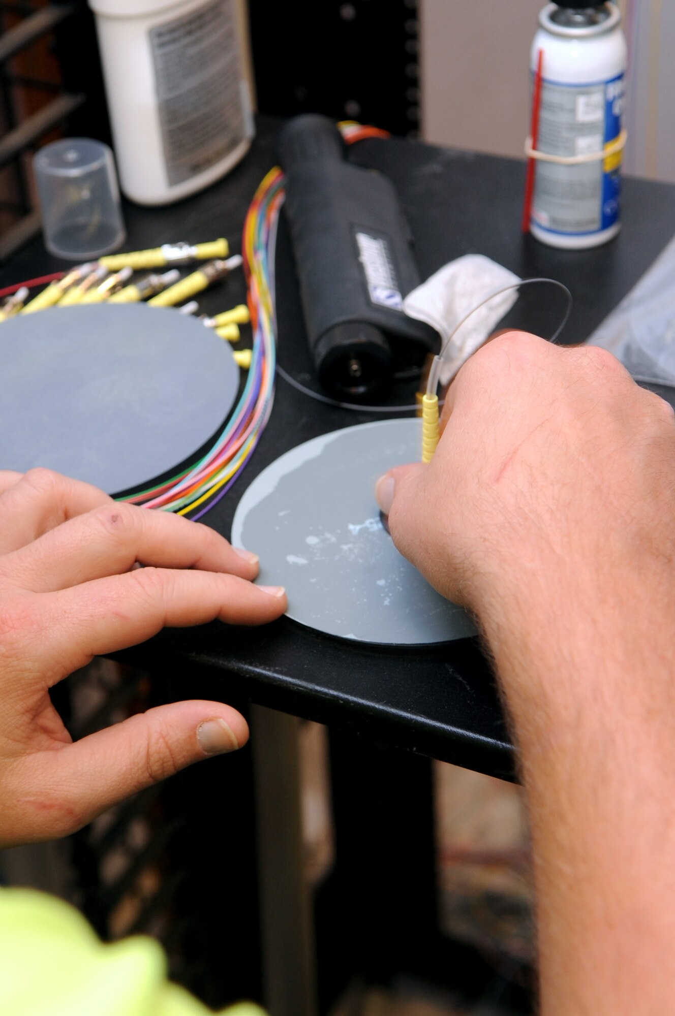 Chris Hayes, a contracted communication technician, polishes fiber-optic connectors inside a newly renovated building on Barksdale Air Force Base, La., July 13. The fiber-optic cable is used for network connectivity. (U.S. Air Force photo/Senior Airman La'Shanette V. Garrett)(RELEASED)