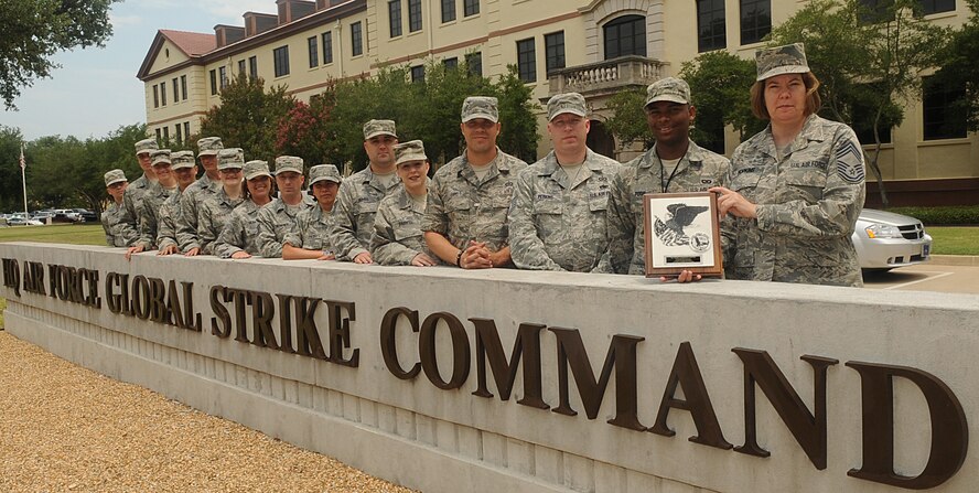 Chief Master Sgt. Laura Hopkins, Air Force Global Strike Command, and her Airmen pose with the Air Force Headquarters Command Element Post of the Year Award in front of AFGSC on Barksdale Air Force Base, La., July 14. When not handling personnel or manning issues, Hopkins is addressing  Air Force headquarters and Global Strike policies or policy development, in addition to reviewing enlisted performance reports and decorations. (U.S. Air Force photo/Senior Airman Kristin High)(RELEASED)