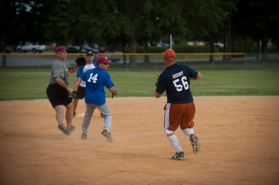 Airmen from the 23rd Civil Engineer Squadron catch James Roberts, 23rd Comptroller Squadron, in a rundown during a tournament game at Moody Air Force Base, Ga., July 13, 2011. A rundown is when a player attempts to advance to the next base but is cut off by the defensive player, who has a live ball and attempts to tag him out before he can return to his previous base. (U.S. Air Force photo by Airman 1st Class Joshua Green/Released)
