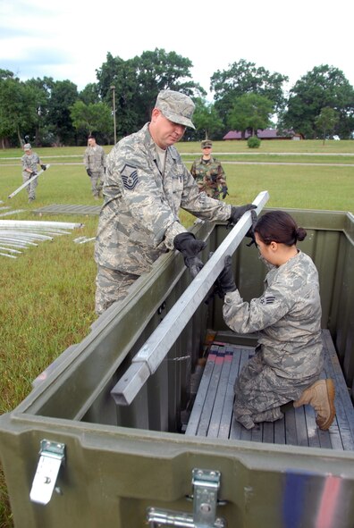 Senior Airman Samantha Rufh of the 178th Medical Group, Springfield, Ohio, unloads a tent support to Master Sgt. Chuck Opauski of the 178 MDG, during Expeditionary Medical Support Basic refresher training July 12 as part of Patriot Exercise 2011 at Volk Field Combat Readiness Training Center, Wis.  EMEDS Basic is designed to facilitate surgical and primary medical care in a deployed environment. (U.S. Air Force photo by Senior Airman Amy N. Adducchio/Released)