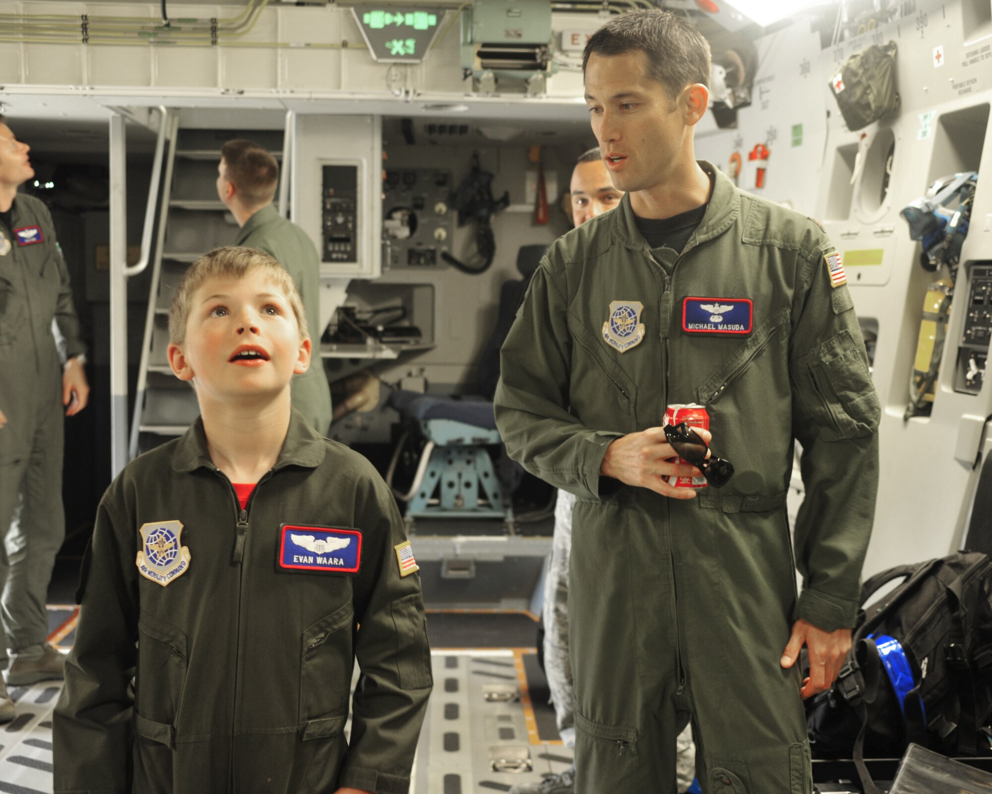 Maj. Michael Masuda, 4th Airlift Squadron pilot, shares several facts about the C-17 Globemaster III to Evan Waara, "Pilot for a Day," July 7 at Joint Base Lewis-McChord, Wash. Major Masuda was the Pilot for a Day program coordinator. (Air Force photo/Staff Sgt. Frances Kriss)