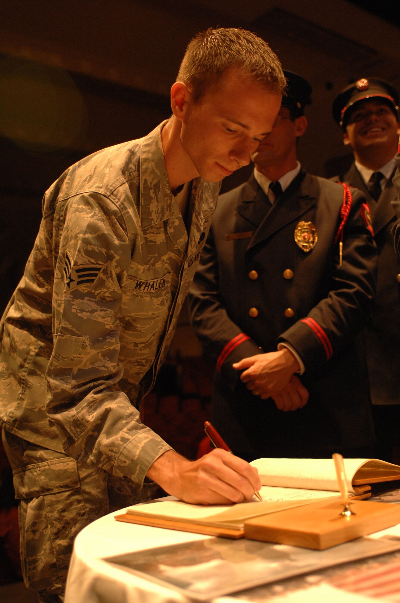 U.S. Air Force Senior Airman Steven Whalen, 355th Equipment Maintenance Squadron, signs the guestbook at the Flag Stitching ceremony held at the University of Arizona’s Centennial Hall in Tucson, Ariz. July 8. The National 9/11 Flag Tour is a grassroots effort to repair the 30-foot flag that hung across from the Twin Towers and was damaged during the attacks of Sept. 11. Retired flags from across the 50 states are being used in the restoration. (U.S. Air Force photo by Airman 1st Class Saphfire Cook)