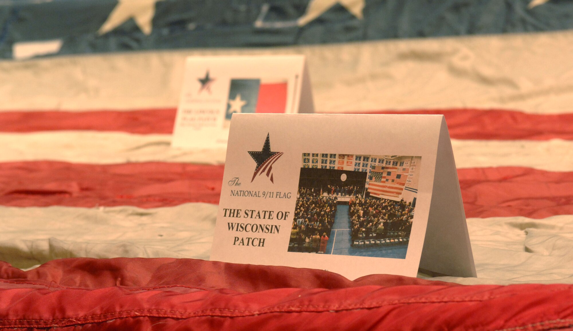 Placards representing each flag sewn into the original were displayed for attendees of the Flag Stitching ceremony held at the University of Arizona’s Centennial Hall in Tucson, Ariz. July 8. The National 9/11 Flag Tour is a grassroots effort to repair the 30-foot flag that hung across from the Twin Towers and was damaged during the attacks of Sept. 11. Retired flags from across the 50 states are being used in the restoration. (U.S. Air Force photo by Airman 1st Class Saphfire Cook)