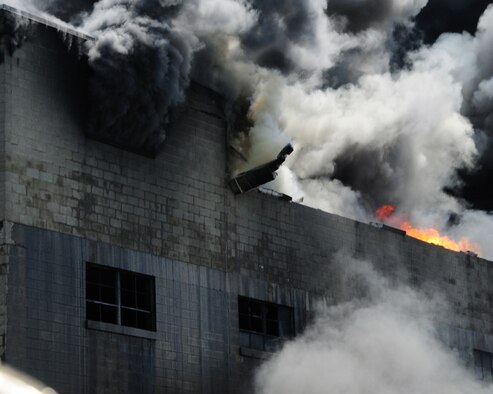 The structure is coming apart from extreme heat. Niagara Falls Air Reserve Station Firefighters responded to a call for mutual aid support. The three alarm fire at the warehouse in Buffalo started at approximately 5 a.m. on July 13, 2011. The Air Force firefighters were there to support the Buffalo Fire Department with back up foam to be used on a huge fire at a warehouse that stored oil, grease, and propane. (U.S. Air Force Reserve photo by Peter Borys) 

