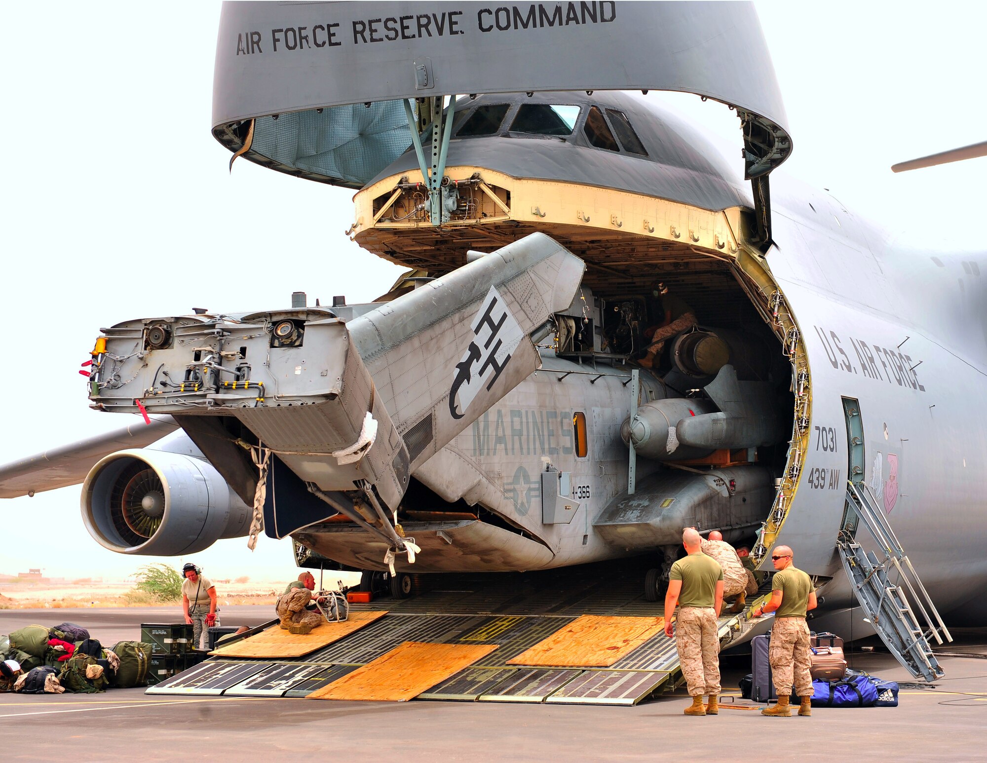 CAMP LEMONNIER, Djibouti (July 14, 2011) -- Marines from Marine Heavy Helicopter Squadron 464, stationed at Camp Lemonnier, Combined Joint Task Force Horn Africa, in Djibouti, prepare to unload a Marine CH-53E Super Stallion helicopter, July 14, from an Air Force Reserve Command C-5B assigned to the 439th Airlift Wing, Westover Air Reserve Base, Mass. Two CH-53E helicopters were delivered to augment readiness and support regional operations in East Africa. (U.S. Navy photo/Mass Communication Specialist 2nd Timothy Wilson)