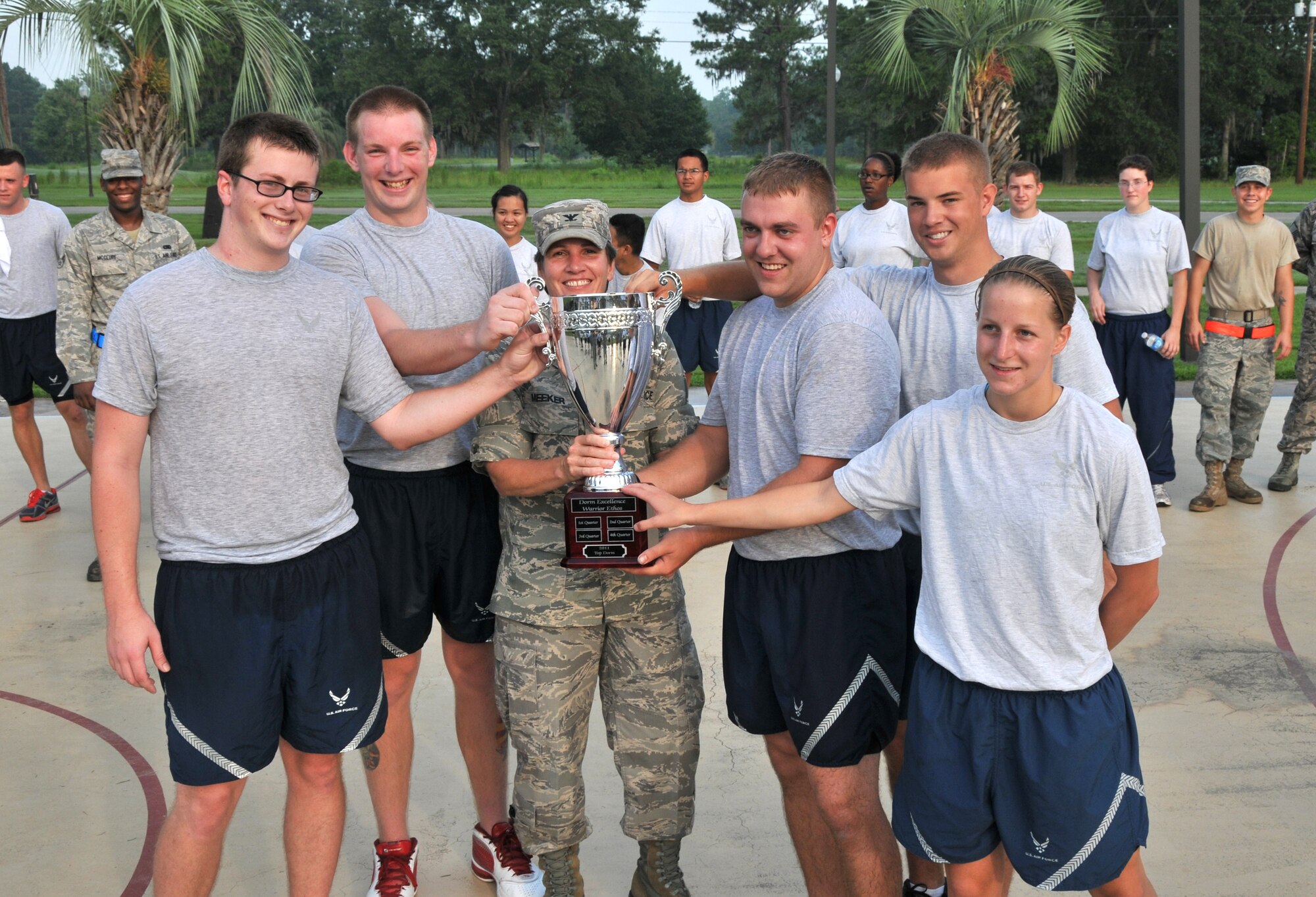Col. Martha Meeker and residents of a Dormitory 466 pose for a group photo July 12 on Joint Base Charleston - Air Base.  Airmen from Dormitory 466 outshined five other dormitories in fitness, dormitory inspections, community involvement and camaraderie during the Dorm Excellence Warrior Ethos challenge. Meeker is the Joint Base Charleston commander. (U.S. Air Force photo/ Airman 1st Class Jared Trimarchi) 
