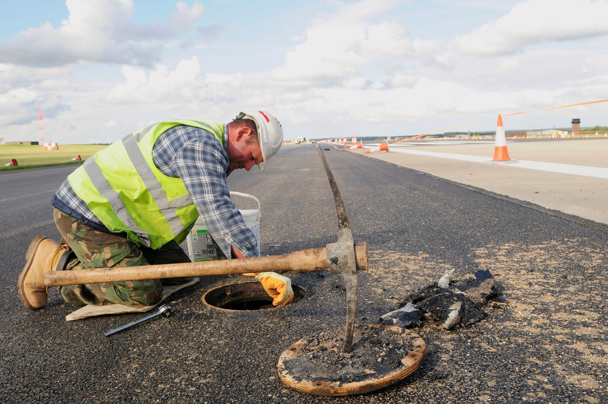 ROYAL AIR FORCE LAKENHEATH, England -- Dean Hayward, a construction worker with Volker Fitzpatrick contracting, cleans out a light fixture on the RAF Lakenheath flightline, July 7, 2011.  The runway closure is part of a three year plan to renovate the entire flightline and is in the final phase of construction.  The project is scheduled for completion by July 18, 2011.  (U.S. Air Force photo/Staff Sgt. Connor Estes)
