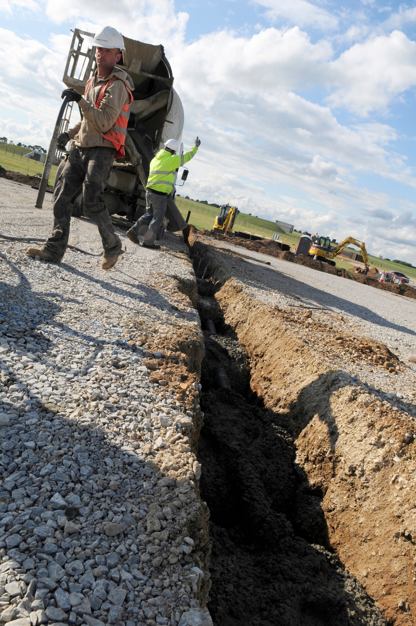 ROYAL AIR FORCE LAKENHEATH, England -- Construction workers with Volker Fitzpatrick contracting, fill a trench with concrete on the closed RAF Lakenheath flightline, July 7, 2011.  The runway closure is part of a three year plan to renovate the entire flightline and is in the final phase of construction.  The project is scheduled for completion by July 18, 2011.  (U.S. Air Force photo/Staff Sgt. Connor Estes)
