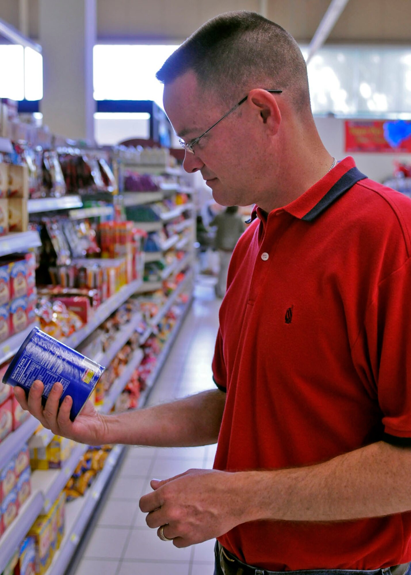 SPANGDAHLEM AIR BASE, Germany -- Lt. Col. Justin Hickman, 606th Air Control Squadron commander, inspects a product here July 9 during the commissary re-opening. A renovation project expanded the floor size by 11,000 square feet, added 2,500 new items to the shelf inventory and created more space for shoppers. (U.S. Air Force photo / Senior Airman Daryl Knee)