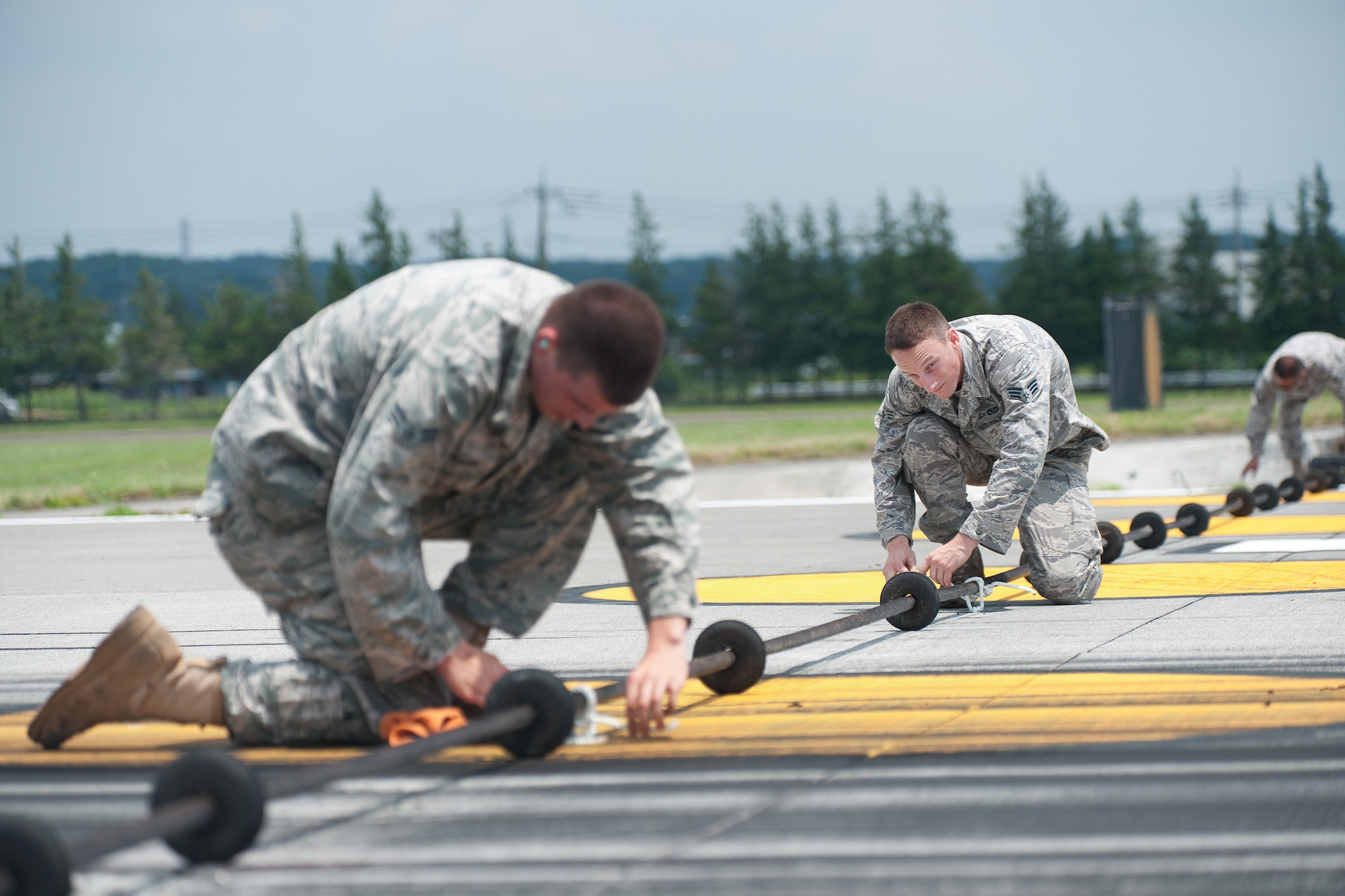 YOKOTA AIR BASE, Japan -- Airmen from the 374th Civil Engineer Squadron barrier maintenance team set up equipment in preparation for an annual barrier system certification test at Yokota Air Base, Japan, July 13, 2011. The system is used in the event of an emergency when a aircraft cannot stop on its own. (U.S. Air Force photo/Osakabe Yasuo) 