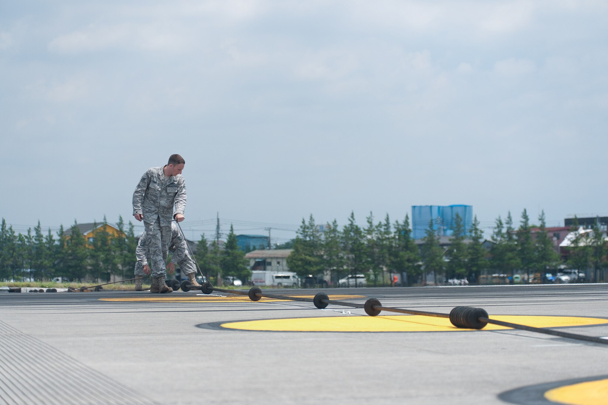YOKOTA AIR BASE, Japan -- Senior Airman Daniel Knowlton, a member of the 374th Civil Engineer Squadron barrier maintenance team, inspects an aircraft arresting barrier system before testing at Yokota Air Base, Japan, July 13, 2011. The barrier maintenance team performs annual certification tests on the system which is used in the event of an emergency where an aircraft cannot stop on its own. (U.S. Air Force photo/Osakabe Yasuo)