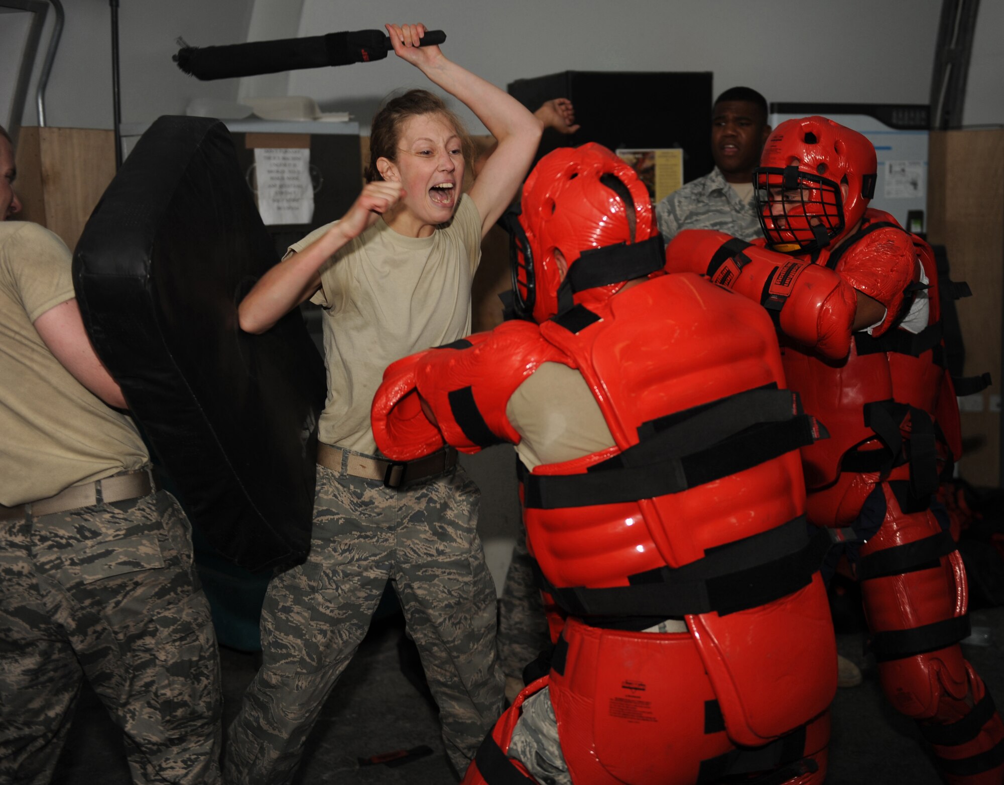 Cadet Yannie Horth yells out commands at two attackers during a baton training drill with the 380th Expeditionary Security Forces Squadron. Horth is here as part of Operation Air Force-Deployed, a program designed to give cadets a firsthand view of a deployment. (U.S. Air Force photo/Master Sgt. Chance Babin)