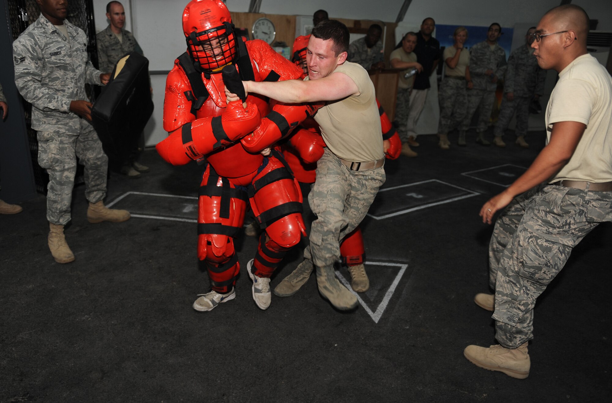 Cadet Jonathan Hagan fights off two attackers during a baton training drill with the 380th Expeditionary Security Forces Squadron. Hagan is here as part of Operation Air Force-Deployed, a program designed to give cadets a firsthand view of a deployment. (U.S. Air Force photo/Master Sgt. Chance Babin)