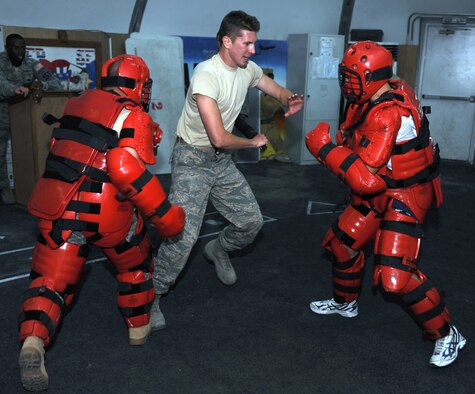 Cadet Daniel Brand fights off two attackers during a baton training drill with the 380th Expeditionary Security Forces Squadron. Brand is here as part of Operation Air Force-Deployed, a program designed to give cadets a firsthand view of a deployment. (U.S. Air Force photo/Master Sgt. Chance Babin)