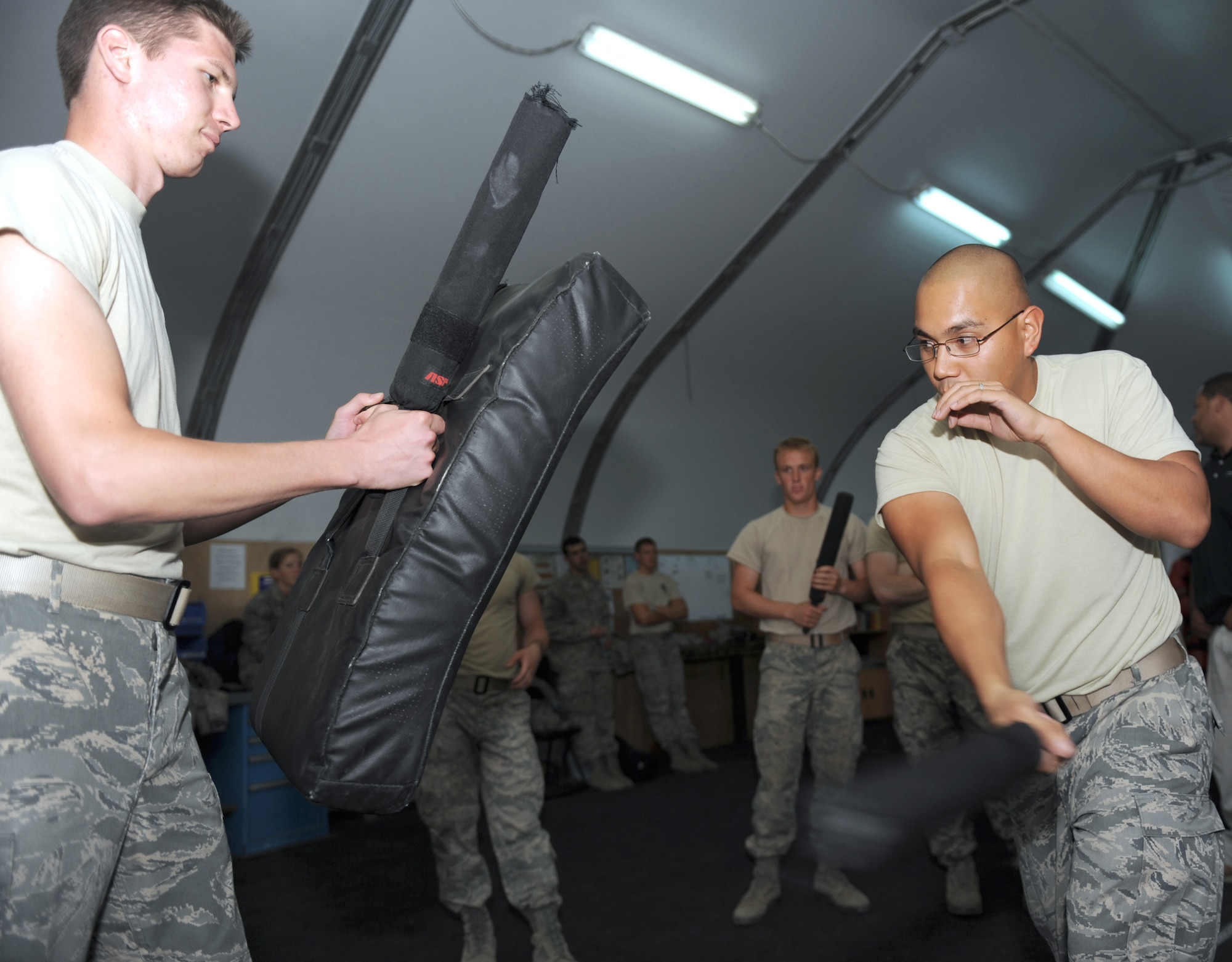 Staff Sgt. Travis Martho, a security forces trainer with the 380th Expeditionary Security Forces Squadron, demonstrates how to use a baton during a training session with a group of cadets from the U.S. Air Force Academy. The cadets are here as part of Operation Air Force-Deployed, a program designed to give cadets a firsthand view of a deployment. (U.S. Air Force photo/Master Sgt. Chance Babin)