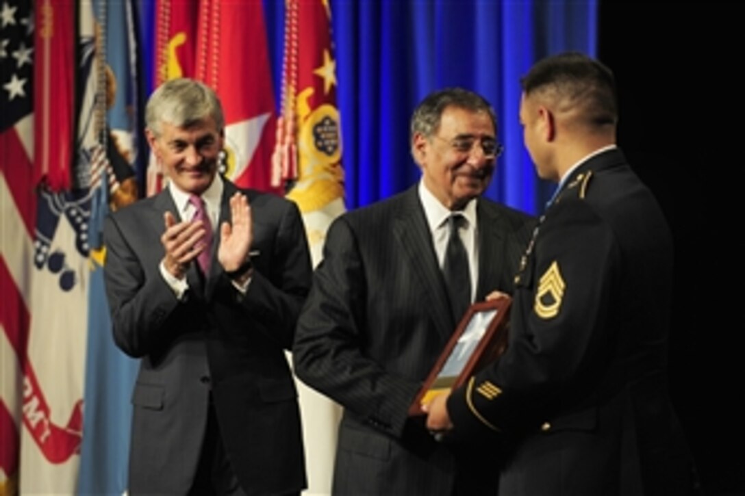 Medal of Honor recipient Sgt. 1st Class Leroy A. Petry receives the Medal of Honor flag from Secretary of Defense Leon E. Panetta as Secretary of the Army John McHugh applauds during a ceremony inducting Petry into the Hall of Heroes in the Pentagon on July 13, 2011.  