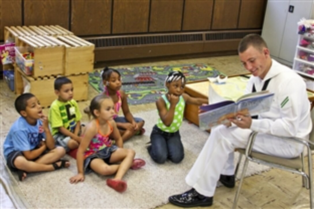 U.S. Navy Seaman Apprentice Chris Donahue reads to children at the Cameron Community Ministries during a Rochester Navy Week 2011 event in Rochester, New York, July 13, 2011. Donahue is assigned to the Navy Operation Support Center Rochester. The Navy plans to sponsor 21 Navy weeks across America this year.