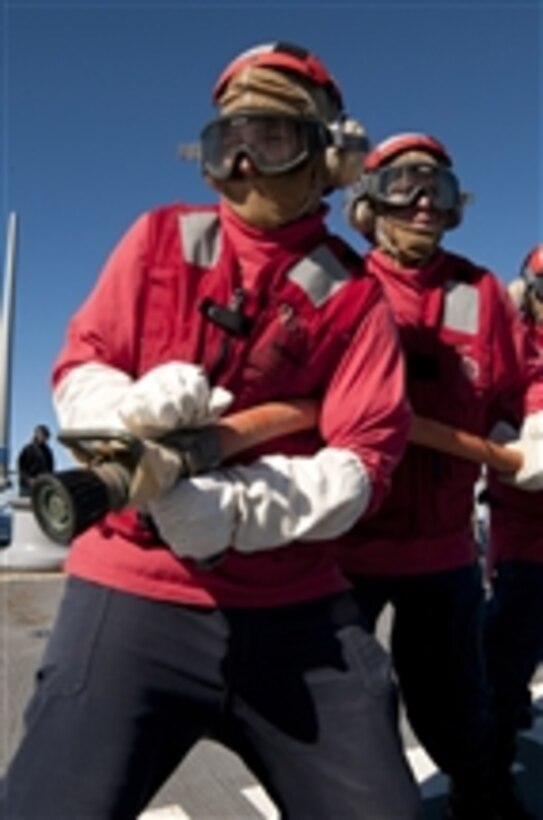 Petty Officer 3rd Class Jack Morris mans a hose during a crash and smash drill aboard the guided-missile destroyer USS Fitzgerald (DDG 62) in the Pacific Ocean on July 11, 2011.  