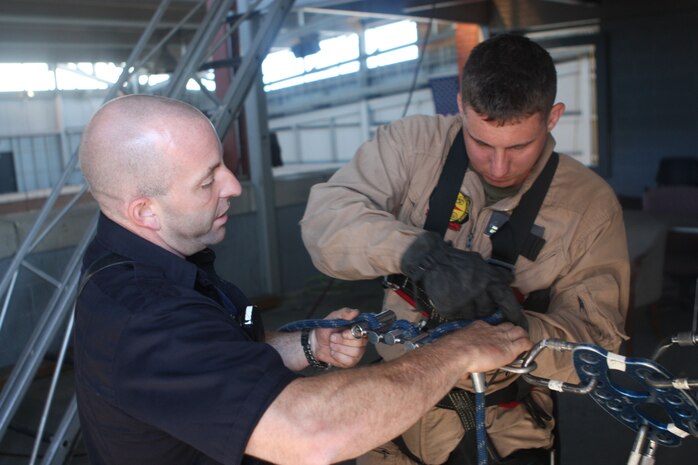 A Marine with Initial Response Force B, Chemical Biological Incident Response Force gets cross training in rope rescue from a New York City Fire Department’s Special Operations Command fire fighter. Marines and sailors of CBIRF went through a week-long training evolution to involve vehicle extrication, rope rescue, and breaching and breaking through concrete. CBIRF’s Marines and sailors have trained with FDNY since July of 2000. Deputy Chief Raymond M. Downey, of FDNY’s SOC, helped CBIRF develop their technical rescue program before he later died on 9/11 in the World Trade Center towers. (released)