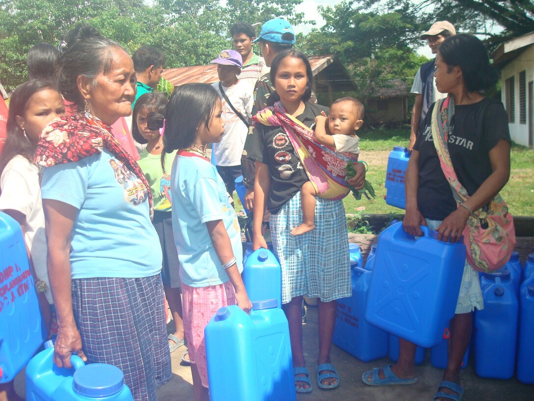 Local people line up with five-gallon water jugs, July 15, to receive purified water at a water distribution area in Culandanum, Palaw-an. A cholera outbreak was declared, April 1, in Culandanum after at least 11 people died due to severe diarrhea, vomiting and dehydration believed to be caused by contaminated water.