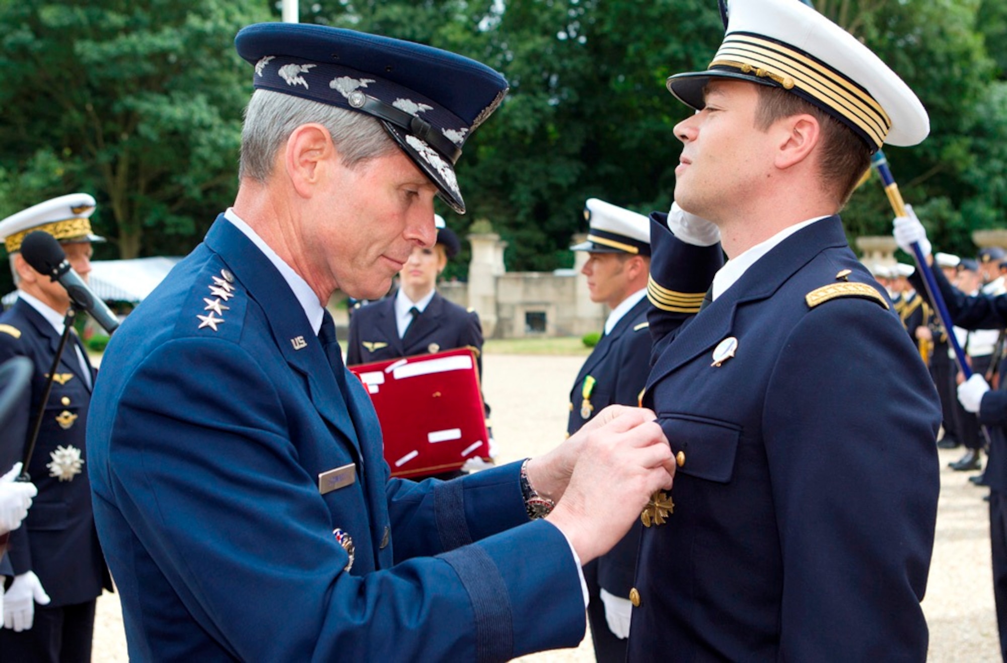 Air Force Chief of Staff Gen. Norton Schwartz pins the Distinguished Flying Cross with Valor on the uniform of French air force Maj. Guillaume Vernet July 13, 2011, at the Lafayette Escadrille Memorial in Marnes-la-Coquette, France.  Vernet was awarded the decoration for repeatedly flying into hostile territory in December 2009 while deployed to Afghanistan as an exchange officer with the 41st Rescue Squadron from Moody Air Force Base, Ga.  During that mission, Vernet rescued an urgent casualty whose injury put the lives of 160 British soldiers in jeopardy.  (Courtesy photo)