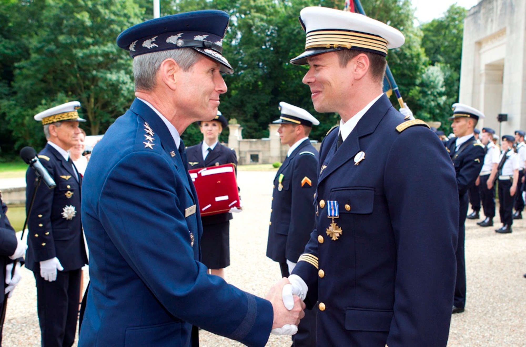 Air Force Chief of Staff Gen. Norton Schwartz congratulates French air force Maj. Guillaume Vernet after presenting him with the Distinguished Flying Cross with Valor July 13, 2011, at the Lafayette Escadrille Memorial in Marnes-la-Coquette, France.  Vernet was awarded the decoration for repeatedly flying into hostile territory in December 2009 while deployed to Afghanistan as an exchange officer with the 41st Rescue Squadron from Moody Air Force Base, Ga.  During that mission, Vernet rescued an urgent casualty whose injury put the lives of 160 British soldiers in jeopardy.  (Courtesy photo)