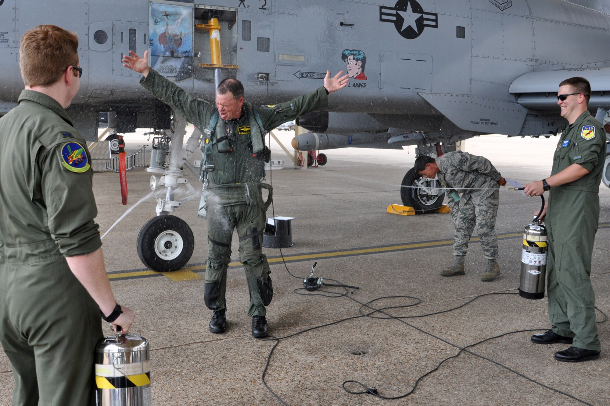 Lt. Col. James Macaulay, the deputy commander for the 917th Fighter Group, accepts the inevitable water attack after returning from his final flight with the 47th Fighter Squadron at Barksdale Air Force Base, La., July 15, 2011. Approximately 100 family, friends and co-workers gathered together for the traditional wetting down after a final flight. Colonel Macaulay’s “fini flight” was part of a four-ship flight, during which the pilots surpassed the 20,000 combined hours mark—a feat never before accomplished by four pilots in the A-10. (U. S. Air Force photo/Tech. Sgt. Jeff Walston)