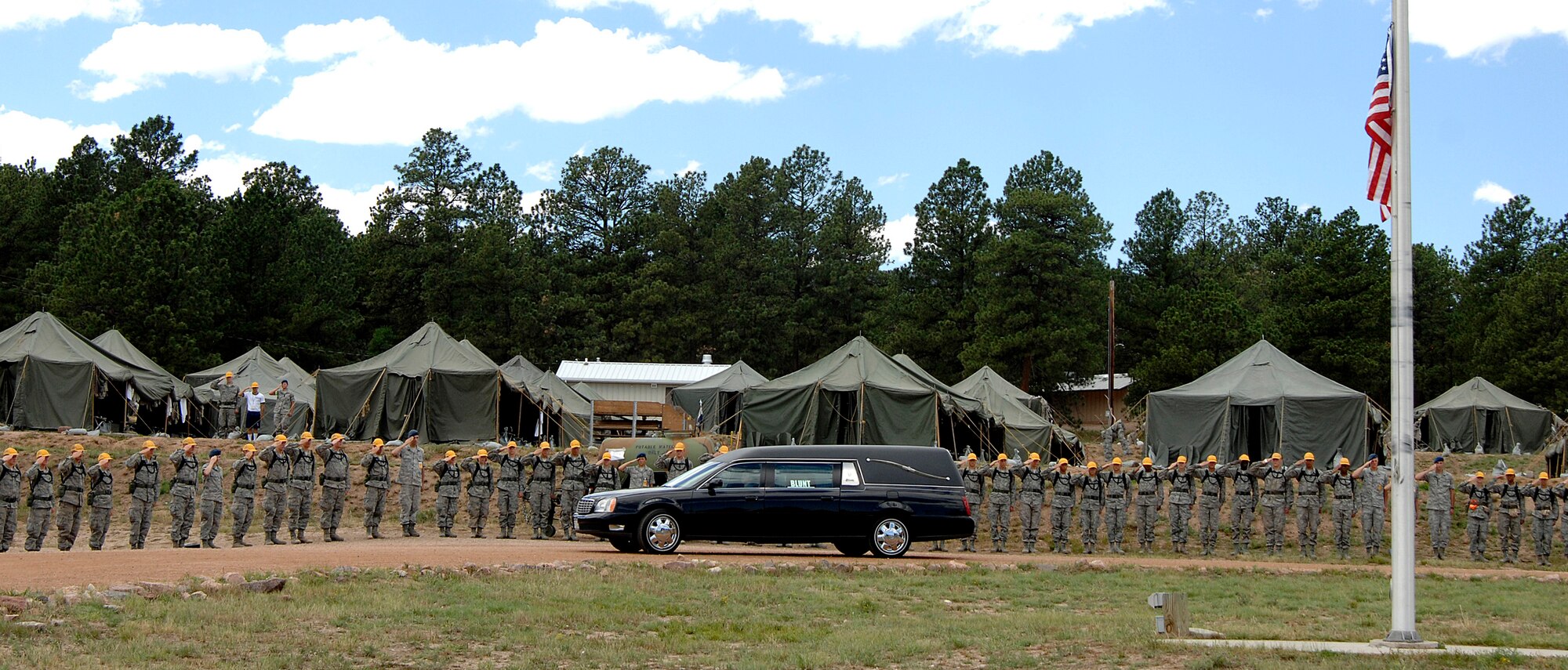 A funeral procession for Col. Leo Boston drives through an honor cordon in Jacks Valley en route to the Air Force Academy cemetery July 15, 2011. Boston was declared missing in action in Vietnam in 1966 after his A-1E Skyraider disappeared over the Black River in North Vietnam. (U.S. Air Force photo/Mike Kaplan)
