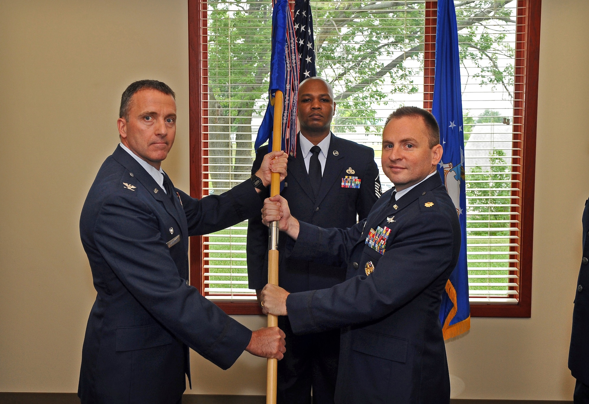 Air Force Maj. Bryan T. Eberhardt, (right), aassumes command of the 55th Strategic Communications Squadron during a change-of-command ceremony held in The Pointe at Rising View, on Offutt Air Force Base, Neb., July 13. Col. Dennis Lisherness, 55th Communications Group commander, presided over the ceremony welcoming Eberhardt to the 55th CG.  (U.S. Air Force Photo by Josh Plueger/ Released)